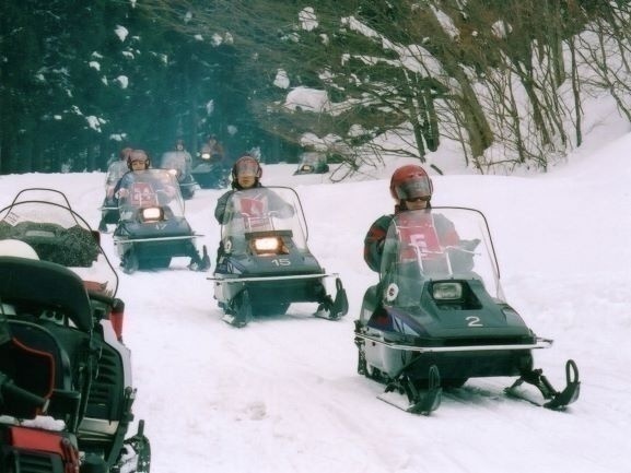 積雪の道を走るスノーモービル